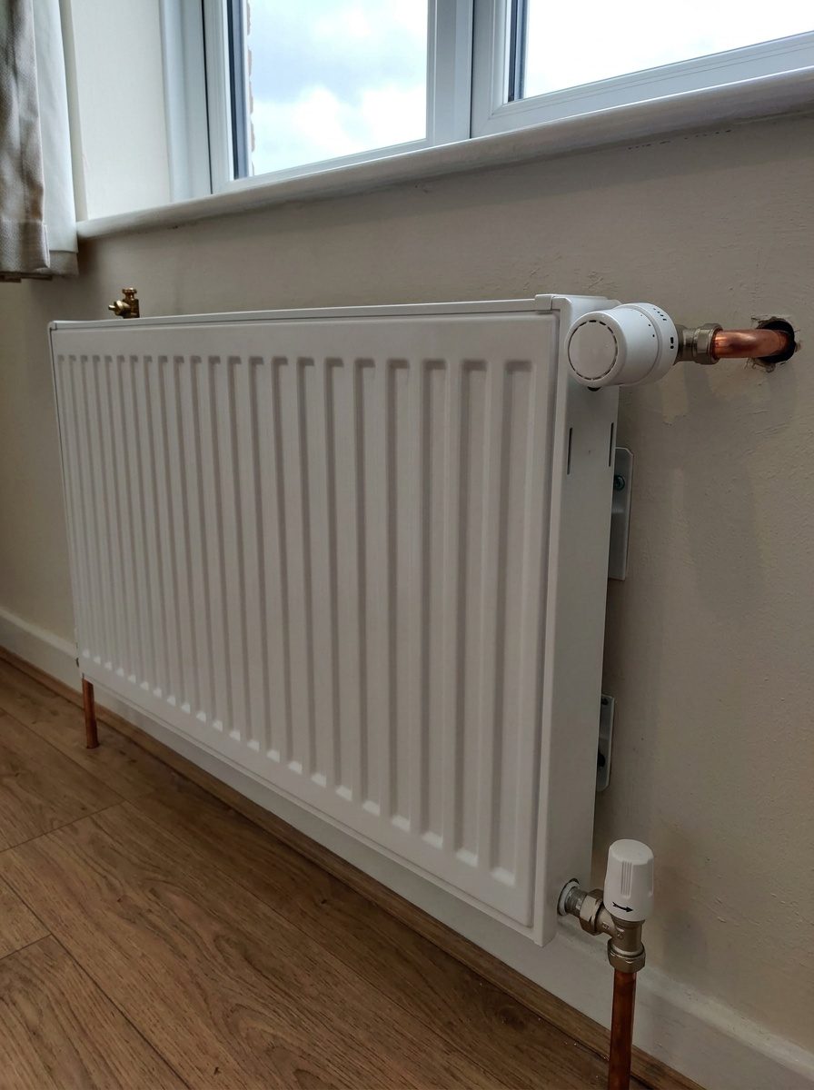 Radiateur posé par un chauffagiste, robinet et coude de réglage raccordés