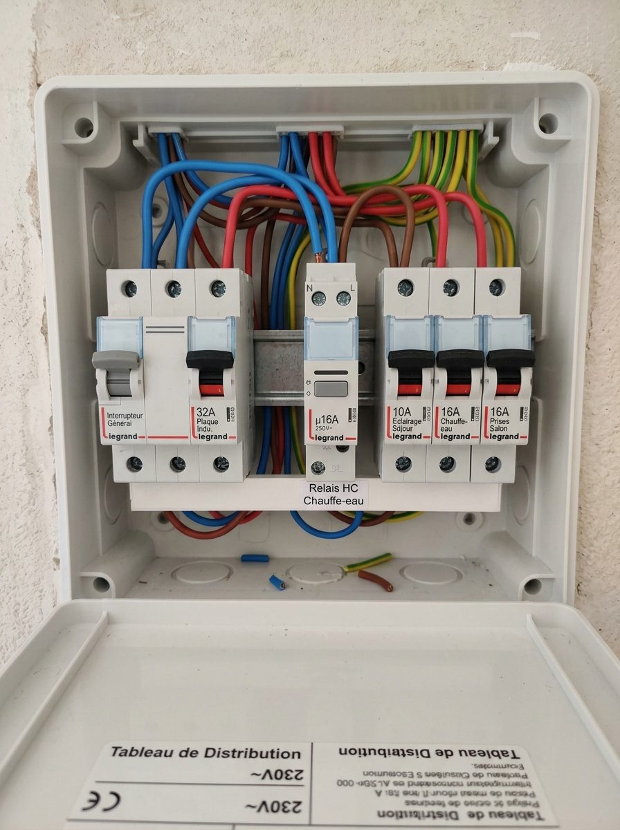 Électricien raccordant un télérupteur dans le tableau après coupure et consignation