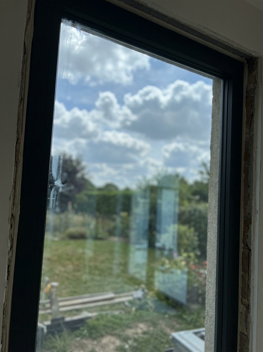 Vitrier posant un vitrage de contrôle solaire sur mesure dans un châssis